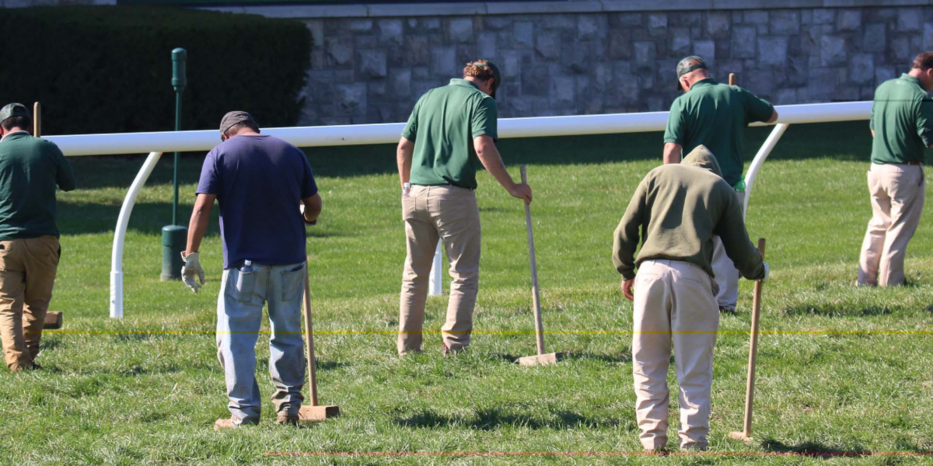 An action shot of Keenfields team members tamping down turf divots.
